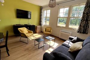 a living room with a couch and chairs and a tv at La Cabarette in Arry