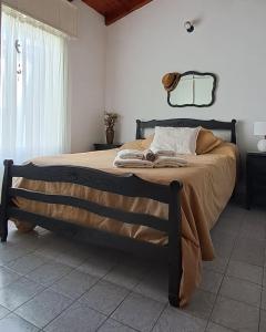 een slaapkamer met een groot bed met een houten frame bij Lugar confortable y tranquilo in Carmen de Patagones