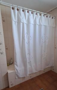 - un rideau de douche blanc dans la salle de bains dans l'établissement Lugar confortable y tranquilo, à Carmen de Patagones