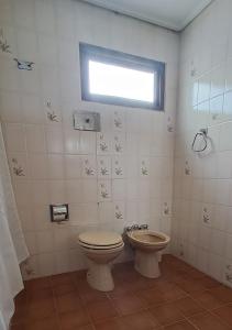 a bathroom with a toilet and a window at Lugar confortable y tranquilo in Patagones