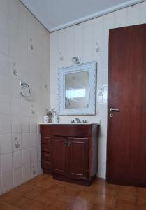 uma casa de banho com um lavatório e um espelho na parede em Lugar confortable y tranquilo em Carmen de Patagones