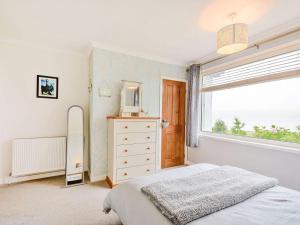 a bedroom with a bed and a window at Cornerways in Blairmore