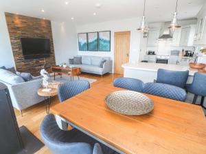 a living room with a table and blue chairs at Seafield, St. Ives in Carbis Bay