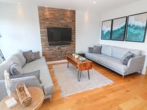 a living room with two couches and a tv at Seafield, St. Ives in Carbis Bay