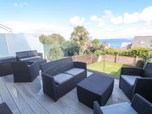 un patio con sillas y mesas en una terraza en Seafield, en Carbis Bay