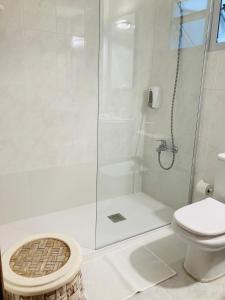 y baño blanco con ducha y aseo. en Tiffany's Apartment, en Las Palmas de Gran Canaria