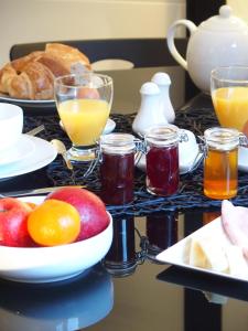 una mesa de desayuno con un bol de fruta y zumo en Bed and Breakfast Le patio, en Montigny-lès-Metz