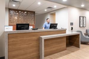 a man standing at a reception desk in a dental office at Candlewood Suites Grand Junction by IHG in Grand Junction