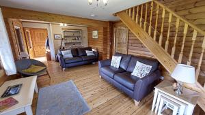 a living room with two couches and a staircase at Eirianfa in Menai Bridge