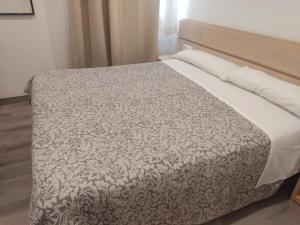 a bedroom with a bed with a white bedspread at Nap Carta Puebla in Oviedo
