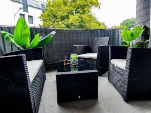 a patio with wicker chairs and a glass table at *****Luxus-Flat im Herzen von Hilden in Hilden