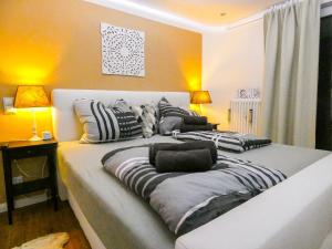 a large bed with striped pillows in a room at *****Luxus-Flat im Herzen von Hilden in Hilden