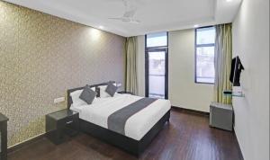 a hotel room with a bed and two windows at Downtown Cyber City in Gurgaon