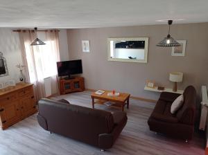 a living room with a couch and a table at Les Gîtes du Triskell, gîte du Feu in Sainte-Tréphine