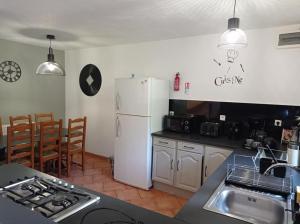 a kitchen with a white refrigerator and a counter top at Les Gîtes du Triskell, gîte du Feu in Sainte-Tréphine