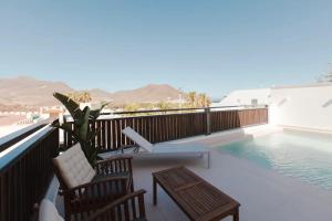 a balcony with a pool and two chairs and a table at Villa Marejada 19 in San José