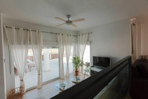 a living room with a ceiling fan and a television at Villa Marejada 19 in San José