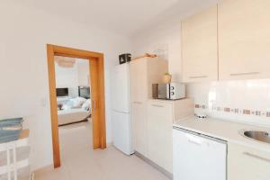 Una cocina blanca con fregadero y refrigerador. en Villa Marejada 19, en San José