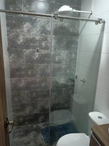 y baño con ducha de cristal y aseo. en Apartamento turístico amoblado Barbosa en Barbosa