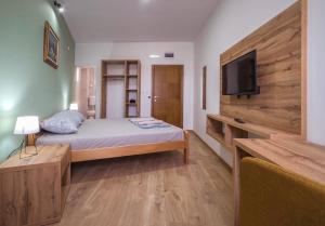 een slaapkamer met een bed en een flatscreen-tv bij Zoe Pirot in Pirot
