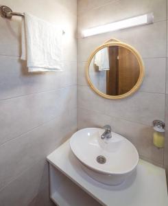 een badkamer met een witte wastafel en een spiegel bij Zoe Pirot in Pirot