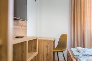 a room with a bed and a desk with a television at Zoe Pirot in Pirot