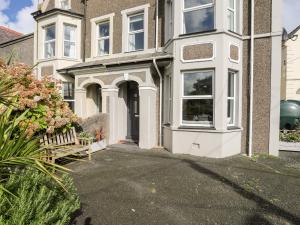 una casa con un banco delante de ella en Bodfan - Morfa Nefyn, en Pwllheli