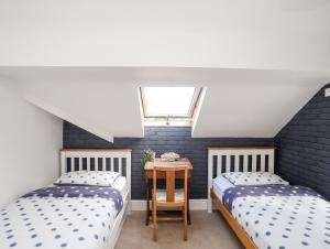 Schlafzimmer im Dachgeschoss mit 2 Betten und einem Fenster in der Unterkunft Bodfan - Morfa Nefyn in Pwllheli