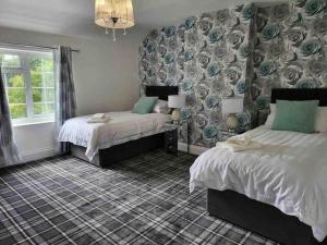 a bedroom with two beds and a patterned wall at Holly Cottage Country Retreat in Wickenby