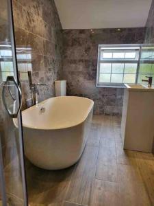 a large white bath tub in a bathroom at Holly Cottage Country Retreat in Wickenby
