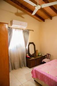 1 dormitorio con cama, tocador y espejo en Hermoso Depto con Piscina en Calle Palma Asunción, en Asunción