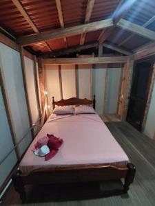 a bedroom with a bed with a pink blanket at Casa LalitoHouse cabaña rustica frente al mar. in Pavones