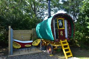 a green airstream truck with a table and chairs at Gypsy Sunrose in Bude