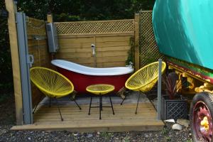 a tub sitting on a deck with two chairs at Gypsy Sunrose in Bude +8 photos