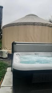 a hot tub in front of a tent at La Lumineuse des yourtes du petit ruisseau in Mandeville