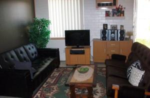 a living room with two couches and a tv at Dover Motel in Moree
