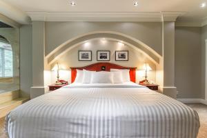 Un dormitorio con una gran cama blanca con un arco encima. en Crown Isle Resort & Golf Community, en Courtenay