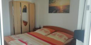 a bedroom with a bed with two pillows at Apartmani kod Rade in Pakoštane