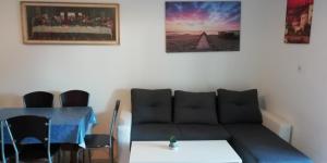 a living room with a couch and a table at Apartmani kod Rade in Pakoštane