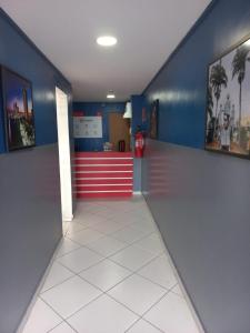 an empty hallway with a red and blue wall at Hotel Kairos in Campina Grande