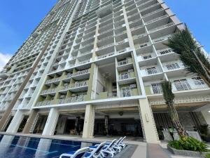 a tall building with a pool in front of it at The celandine staycation condo hotel in quezon city in Manila