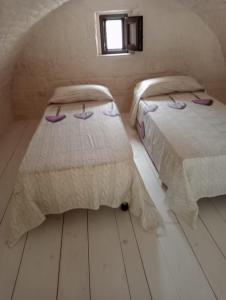 1 Schlafzimmer mit 2 Betten und einem Fenster in der Unterkunft A Due Passi dal Centro - Monte Grappa in Alberobello