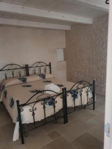 2 Einzelbetten in einem Zimmer mit einer Steinmauer in der Unterkunft A Due Passi dal Centro - Monte Grappa in Alberobello