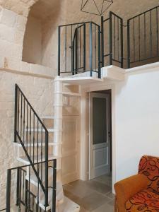 eine Wendeltreppe in einem Wohnzimmer mit einer Treppe in der Unterkunft A Due Passi dal Centro - Monte Grappa in Alberobello