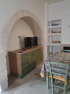 ein Esszimmer mit einem Tisch und einem TV an der Wand in der Unterkunft A Due Passi dal Centro - Monte Grappa in Alberobello