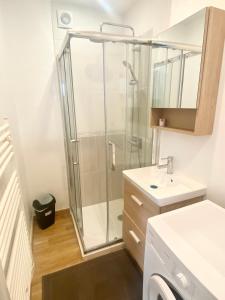 ein Bad mit einer Dusche und einem Waschbecken in der Unterkunft * Le Droma D’or * Appartement Confort * Centre-ville in Calais