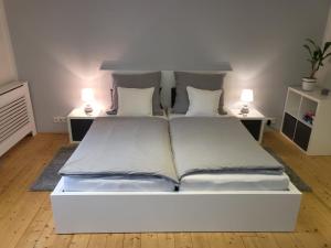 dwa łóżka w pokoju z dwoma lampami na stołach w obiekcie Tritt ein bring Glück herein - Exquisite 75 qm - Messenähe - Parkplatz - Flughafennähe w mieście Düsseldorf