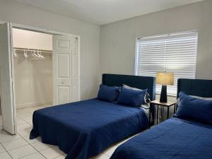- une chambre avec 2 lits dotés d'oreillers bleus dans l'établissement Coral Gable 3BR house Parking &, à Miami