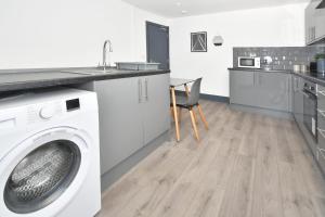 a kitchen with a washing machine and a counter at Townhouse @ Bedford Street Crewe in Crewe