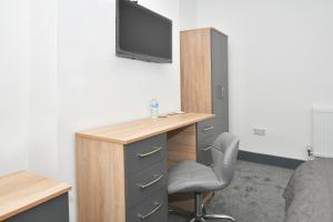 a bedroom with a desk and a tv on a wall at Townhouse @ Bedford Street Crewe in Crewe
